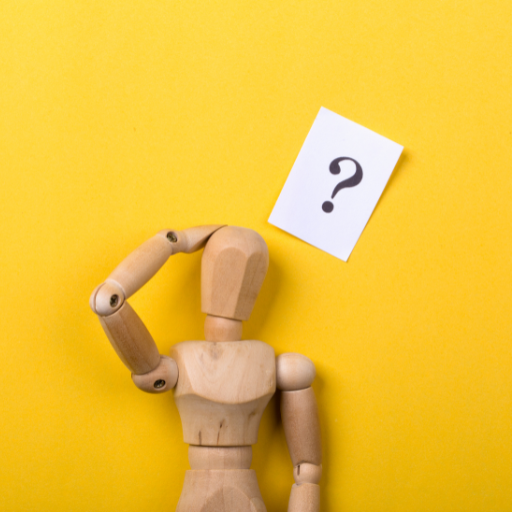 A wooden doll used typically for art with its hand on its head. Above its head a small piece of paper with a question mark. The wall is yellow.